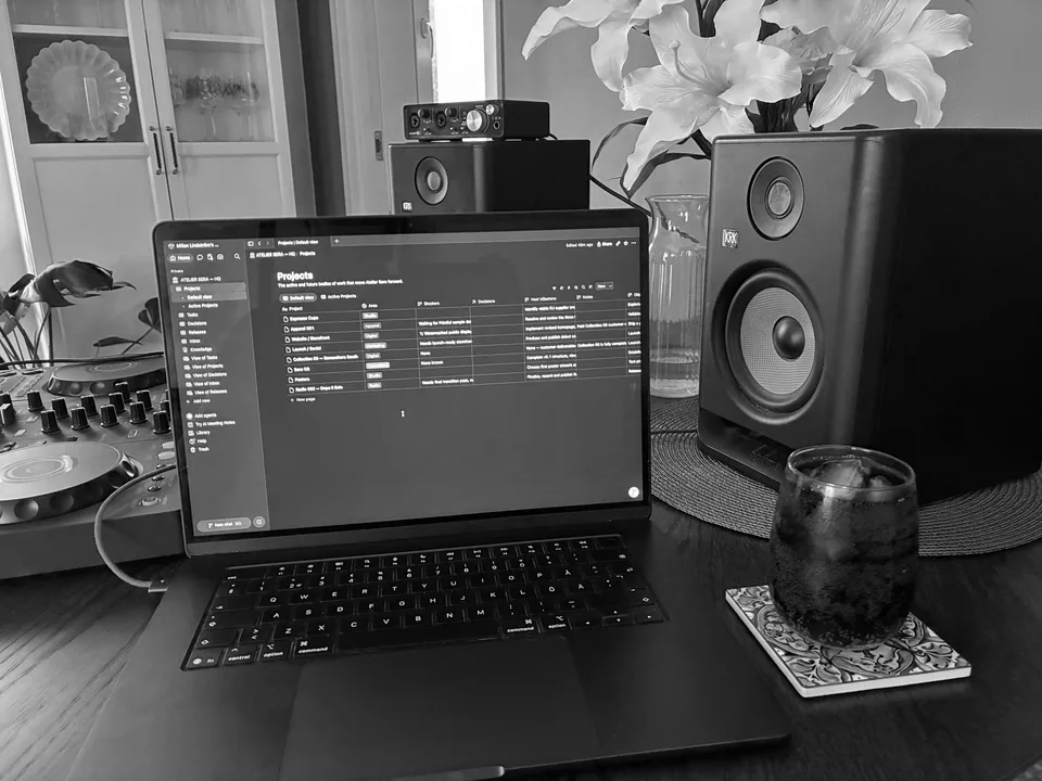 The Atelier Sera workspace, with a MacBook, studio monitors, DJ equipment and working materials on the desk.