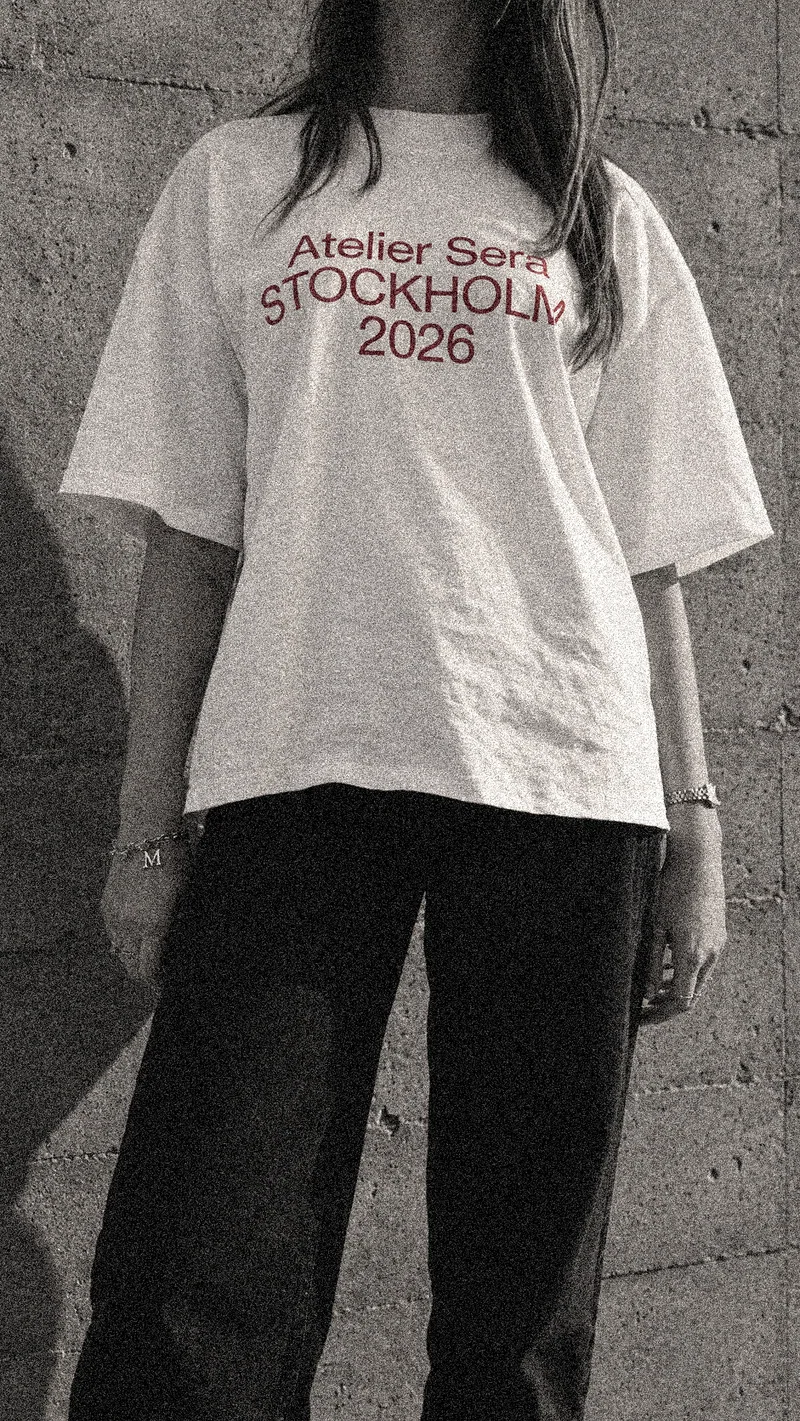 Atelier Sera Stockholm 2026 tee worn from the front, showing the burgundy chest print.